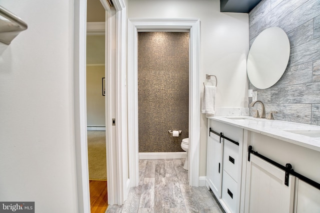 1606 Jeffers Rd, Baltimore, MD 21204 - full bathroom with double vanity, wood finished floors, toilet, and a baseboard heating unit