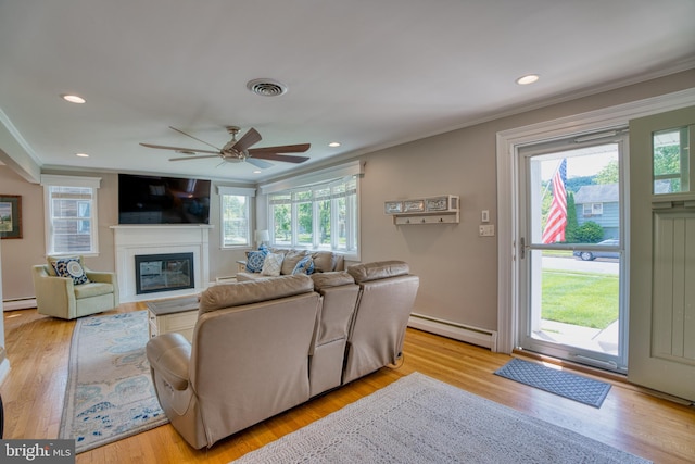 1606 Jeffers Rd, Baltimore, MD 21204 - living area with a baseboard radiator, crown molding, baseboard heating, a glass covered fireplace, and light wood-style floors