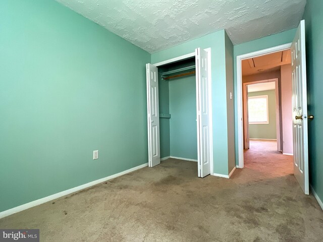 131 Arundel Rd, Pasadena, MD 21122 - unfurnished bedroom featuring attic access, carpet flooring, baseboards, a closet, and a textured ceiling