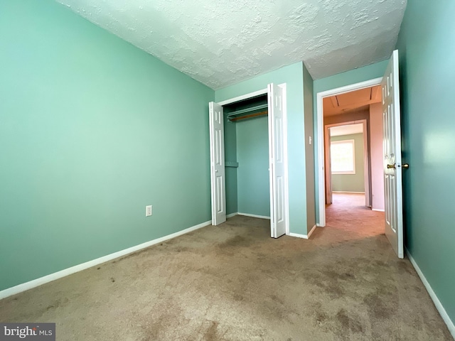131 Arundel Rd, Pasadena, MD 21122 - unfurnished bedroom featuring attic access, carpet floors, baseboards, a closet, and a textured ceiling