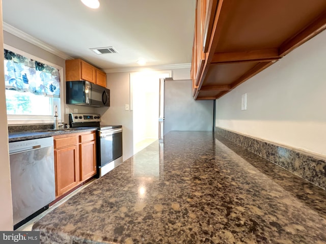 131 Arundel Rd, Pasadena, MD 21122 - kitchen with stainless steel appliances, crown molding, a sink, brown cabinetry, and dark stone countertops