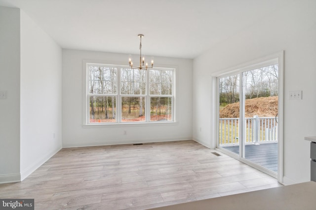 4338 Taviston Ct E, Emmaus, PA 18049 - unfurnished dining area with a chandelier, light wood-type flooring, and baseboards