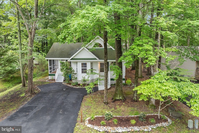 74 Bramblewood Dr, Ocean Pines, MD 21811 - view of front facade featuring roof with shingles, a sunroom, and driveway