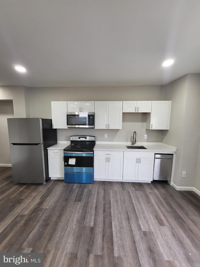 132 N 50th St, Philadelphia, PA 19139 - kitchen with appliances with stainless steel finishes, a sink, white cabinets, light countertops, and dark wood-type flooring