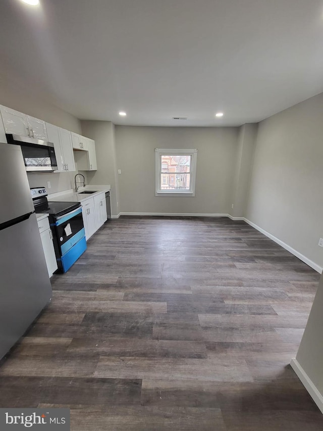 132 N 50th St, Philadelphia, PA 19139 - kitchen with stainless steel appliances, white cabinetry, recessed lighting, dark wood-style floors, and baseboards