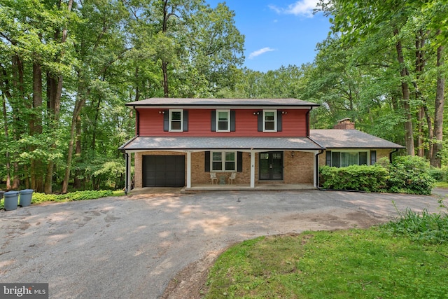 19 Norris Run Ct, Reisterstown, MD 21136 - view of front of property featuring driveway, covered porch, an attached garage, brick siding, and a chimney