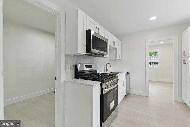 3835 Dresher Rd, Bensalem, PA 19020 - kitchen with stainless steel appliances, a sink, light wood finished floors, white cabinetry, and recessed lighting