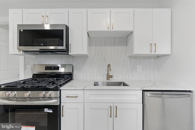 3835 Dresher Rd, Bensalem, PA 19020 - kitchen with stainless steel appliances, a sink, white cabinets, light stone countertops, and decorative backsplash