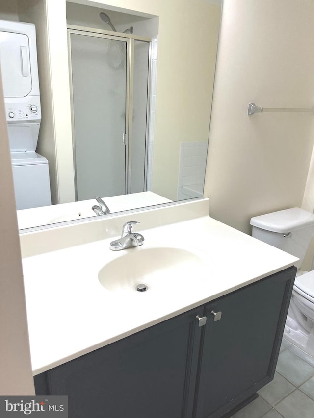 2720 Bellforest Ct Unit 201, Vienna, VA 22180 - full bath featuring stacked washing machine and dryer, toilet, vanity, a shower stall, and tile patterned floors