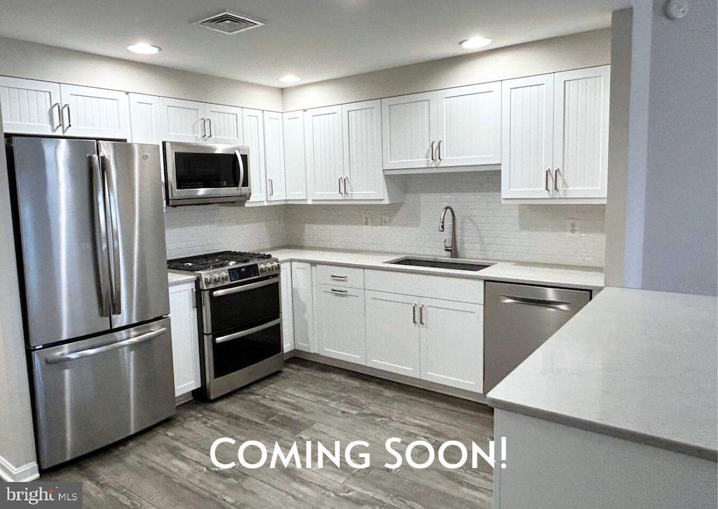 4480 Market Commons Dr Unit 416, Fairfax, VA 22033 - kitchen with stainless steel appliances, a sink, light countertops, wood finished floors, and backsplash