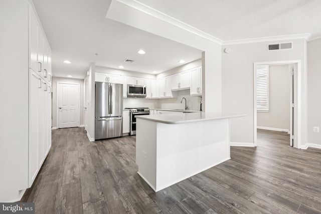 4480 Market Commons Dr Unit 416, Fairfax, VA 22033 - kitchen featuring appliances with stainless steel finishes, a sink, dark wood-style flooring, white cabinetry, and crown molding
