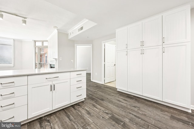 4480 Market Commons Dr Unit 416, Fairfax, VA 22033 - kitchen featuring dark wood-style flooring, white cabinetry, light countertops, crown molding, and baseboards