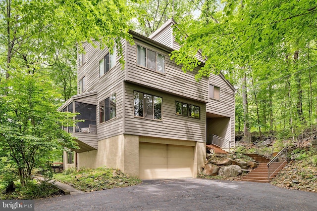 1163 Stuart Rd, Princeton, NJ 08540 - view of front of property with an attached garage, a sunroom, stairway, and asphalt driveway