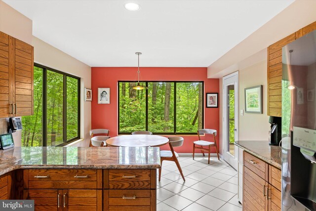 1163 Stuart Rd, Princeton, NJ 08540 - kitchen featuring freestanding refrigerator, a peninsula, light tile patterned floors, brown cabinetry, and hanging light fixtures