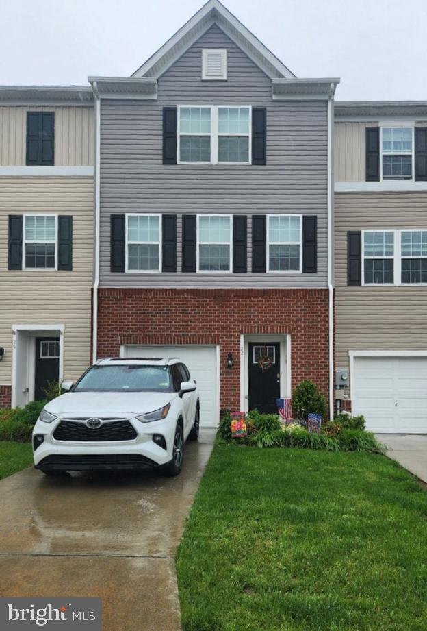 22 Vespucci Ln, Martinsburg, WV 25404 - townhome / multi-family property with driveway, a garage, brick siding, and a front lawn