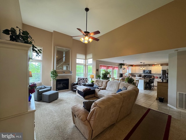 7 Red Fox Ct, Reinholds, PA 17569 - living area with a tile fireplace, a high ceiling, a ceiling fan, light tile patterned floors, and light carpet