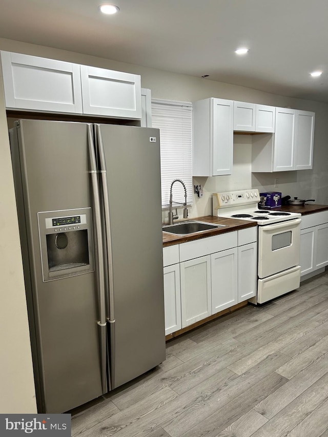 818 Washington St, Cambridge, MD 21613 - kitchen featuring stainless steel fridge, white electric stove, a sink, light wood-style floors, and recessed lighting