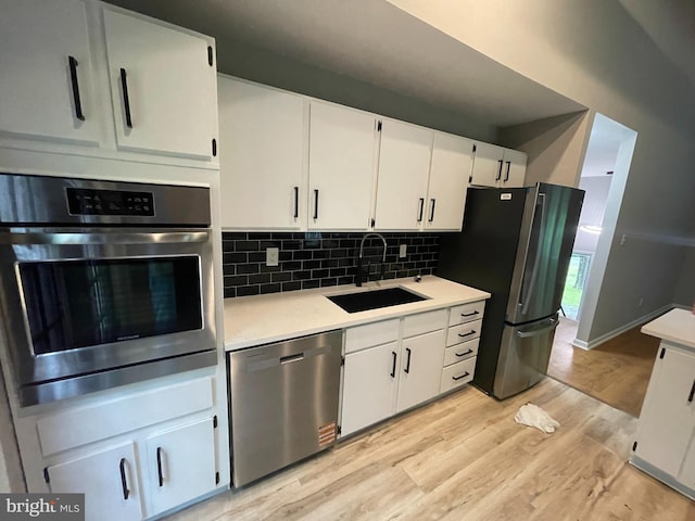 29075 Autumnwood Dr, Mechanicsville, MD 20659 - kitchen featuring appliances with stainless steel finishes, a sink, light wood-style floors, light countertops, and white cabinetry