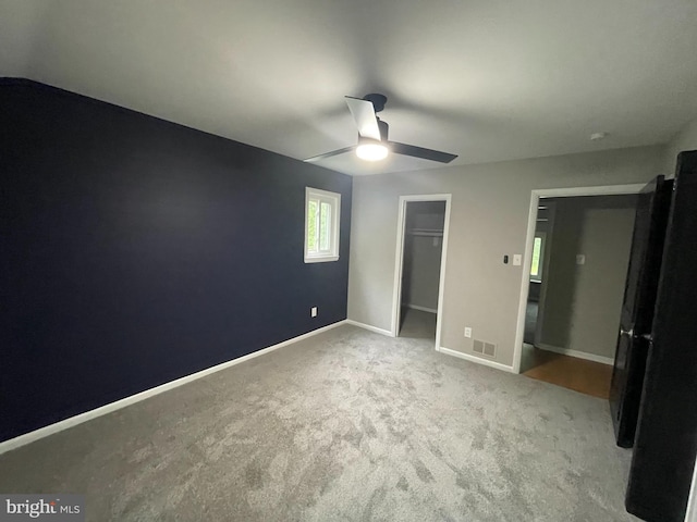 29075 Autumnwood Dr, Mechanicsville, MD 20659 - unfurnished bedroom with carpet floors, a walk in closet, baseboards, a closet, and a ceiling fan