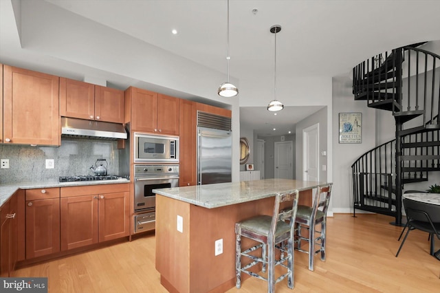2425 L St NW Unit 623, Washington, DC 20037 - kitchen with built in appliances, under cabinet range hood, light wood finished floors, and a warming drawer