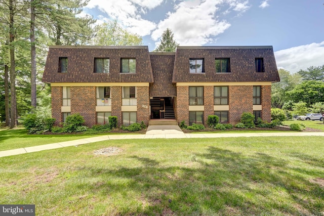 5241 W Running Brook Rd Unit 302, Columbia, MD 21044 - view of front of home featuring a shingled roof, brick siding, and a front lawn