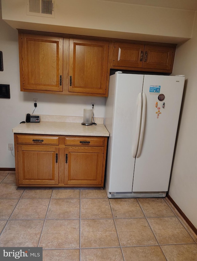 1412 Albert Dr, Bowie, MD 20721 - kitchen with freestanding refrigerator, brown cabinetry, light countertops, and light tile patterned flooring