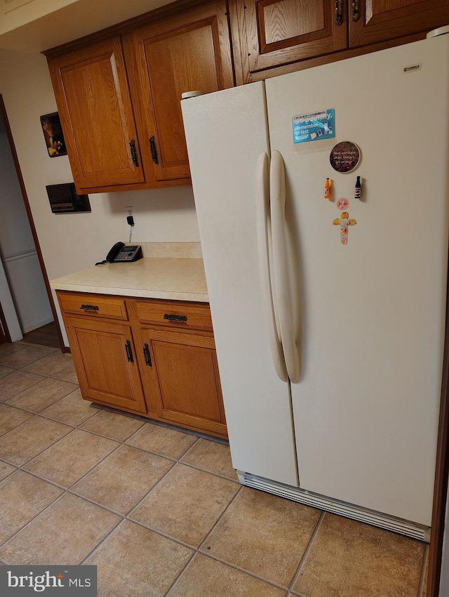 1412 Albert Dr, Bowie, MD 20721 - kitchen featuring freestanding refrigerator, brown cabinetry, light countertops, and light tile patterned flooring
