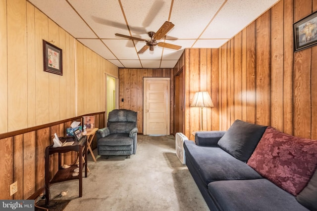 113 N Highland Ave, Baltimore, MD 21224 - sitting room with a ceiling fan, carpet floors, wooden walls, and a drop ceiling