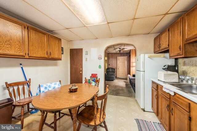 113 N Highland Ave, Baltimore, MD 21224 - dining room featuring a drop ceiling, arched walkways, and light flooring