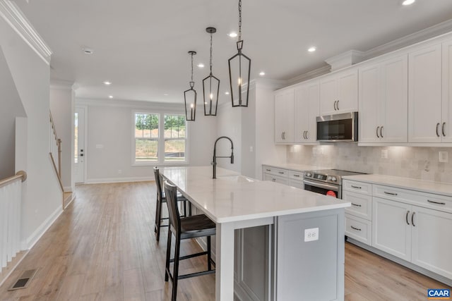 80A Park Ridge Dr, Crozet, VA 22932 - kitchen featuring appliances with stainless steel finishes, a sink, crown molding, an island with sink, and light countertops