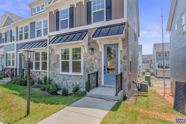 80A Park Ridge Dr, Crozet, VA 22932 - view of property featuring a standing seam roof, stone siding, central air condition unit, a front lawn, and metal roof