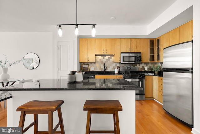 475 K St NW Unit 906, Washington, DC 20001 - kitchen with appliances with stainless steel finishes, backsplash, a kitchen breakfast bar, light wood finished floors, and a sink