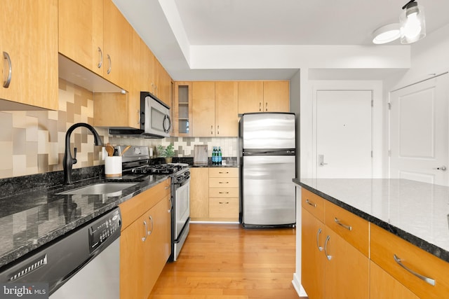 475 K St NW Unit 906, Washington, DC 20001 - kitchen featuring appliances with stainless steel finishes, a sink, light wood-style flooring, decorative backsplash, and dark stone countertops