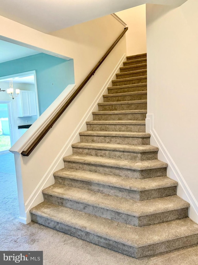 504 S Regulator Dr S, Cambridge, MD 21613 - stairway featuring a chandelier and carpet flooring