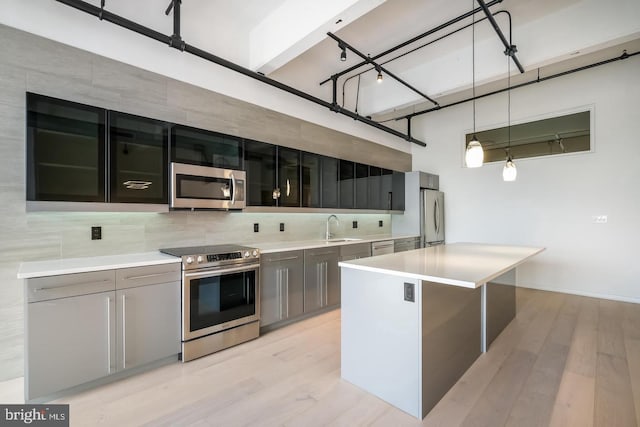 444 N 4th St Unit 415, Philadelphia, PA 19123 - kitchen with stainless steel appliances, a sink, backsplash, light countertops, and light wood-type flooring