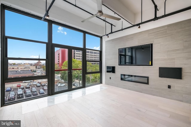 444 N 4th St Unit 415, Philadelphia, PA 19123 - unfurnished living room with a ceiling fan, a glass covered fireplace, and expansive windows