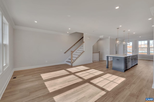 750 Park Ridge Dr, Crozet, VA 22932 - kitchen with a sink, crown molding, baseboards, light wood finished floors, and a center island with sink