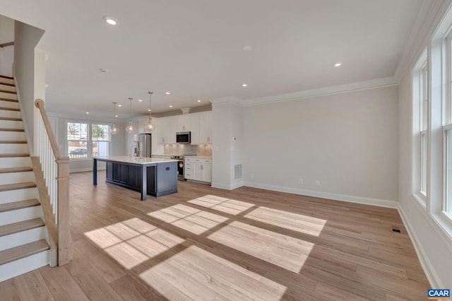750 Park Ridge Dr, Crozet, VA 22932 - kitchen featuring stainless steel appliances, light countertops, white cabinetry, an island with sink, and ornamental molding