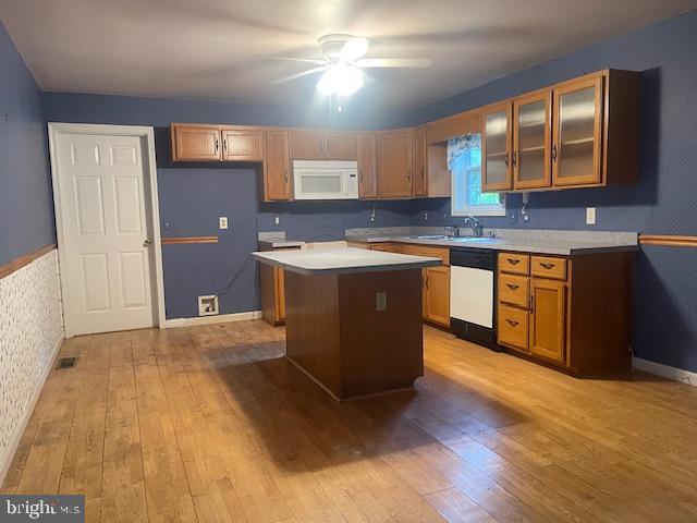 8 Love Creek Dr, Lewes, DE 19958 - kitchen with white appliances, wallpapered walls, light wood-type flooring, light countertops, and a ceiling fan