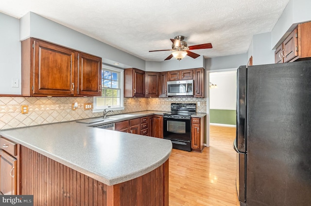 351 Point To Point Rd, Bel Air, MD 21015 - kitchen featuring black appliances, a peninsula, a ceiling fan, light wood finished floors, and decorative backsplash