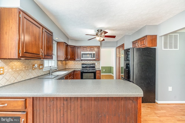 351 Point To Point Rd, Bel Air, MD 21015 - kitchen featuring black appliances, ceiling fan, light wood-style flooring, tasteful backsplash, and a peninsula