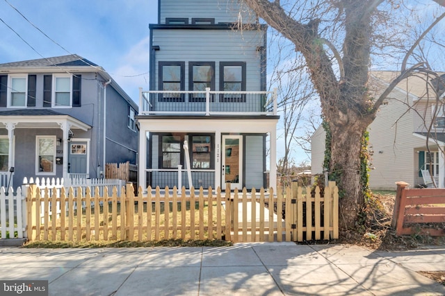 1121 48th Pl NE, Washington, DC 20019 - view of front of property with covered porch, a balcony, a fenced front yard, and a gate