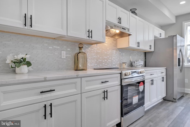 1121 48th Pl NE, Washington, DC 20019 - kitchen featuring appliances with stainless steel finishes, under cabinet range hood, white cabinetry, light wood-type flooring, and backsplash