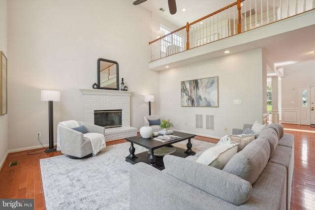 25487 Dabner Dr, Chantilly, VA 20152 - living room with a towering ceiling, wood finished floors, a brick fireplace, baseboards, and ceiling fan