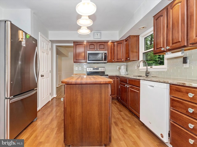 4024 Roop Rd, New Windsor, MD 21776 - kitchen with appliances with stainless steel finishes, a sink, light wood finished floors, a kitchen island, and butcher block counters