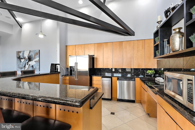 11345 Aristotle Dr Unit 6-311, Fairfax, VA 22030 - kitchen featuring appliances with stainless steel finishes, high vaulted ceiling, decorative backsplash, light tile patterned flooring, and a breakfast bar