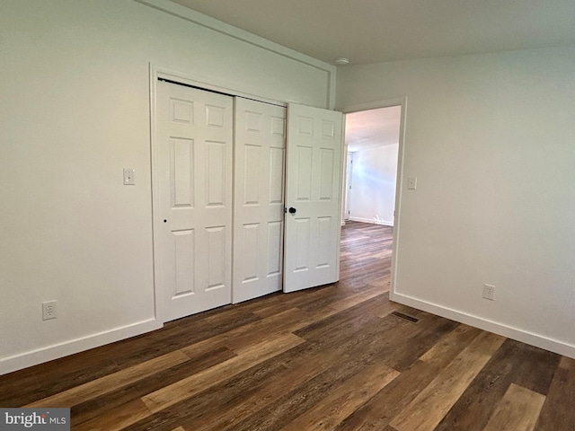 135 Crawford Quarry Rd, Falling Waters, WV 25419 - unfurnished bedroom with baseboards, dark wood-type flooring, and a closet