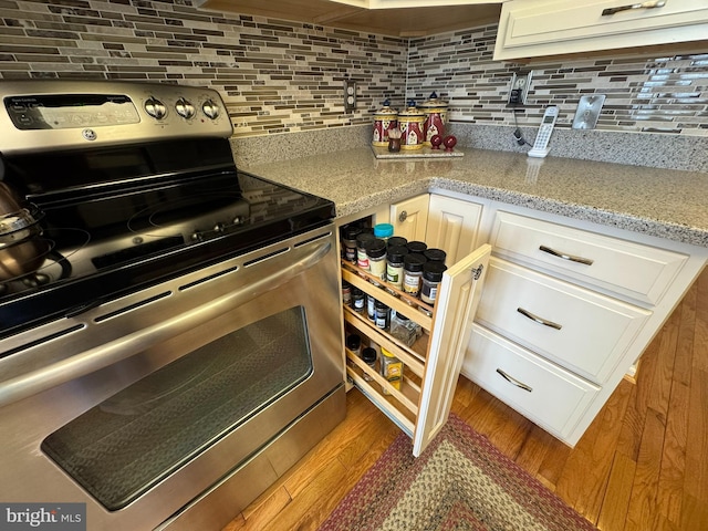 4503-J Dunton Ter, Perry Hall, MD 21128 - kitchen with stainless steel electric range, backsplash, white cabinetry, wood finished floors, and light stone countertops