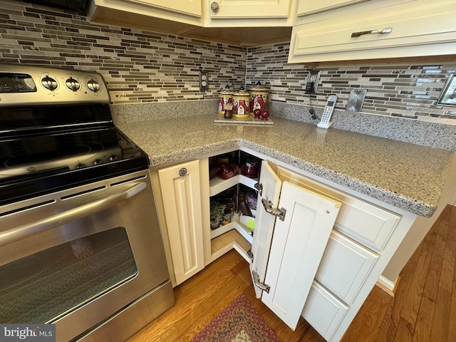 4503-J Dunton Ter, Perry Hall, MD 21128 - kitchen featuring stainless steel electric stove, backsplash, dark wood-style flooring, and light stone countertops