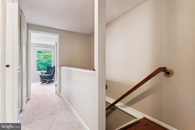 9175 Forest Lawn Ct, Springfield, VA 22152 - corridor with an upstairs landing, a textured ceiling, baseboards, and carpet